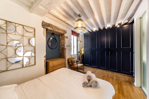 une chambre avec un lit avec des serviettes dessus dans l'établissement Bel appartement du Vieux Lyon - parking inclus AIL, à Lyon