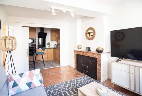 ein Wohnzimmer mit einem Kamin und einem TV in der Unterkunft Modern and cozy in the heart of Saint-Jean AIL in Lyon