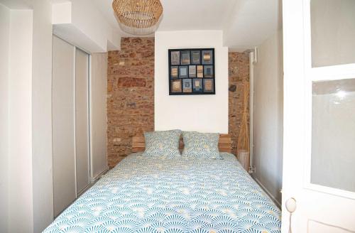Schlafzimmer mit einem Bett mit einer blauen und weißen Bettdecke in der Unterkunft Modern and cozy in the heart of Saint-Jean AIL in Lyon