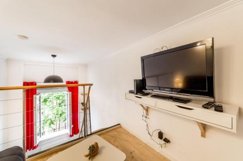 a living room with a large flat screen tv on a wall at The charming studio in Croix-Rousse AIL in Lyon