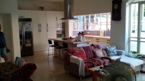 a living room with a couch and a kitchen at Wonderful Garden Apartment in Tel Aviv