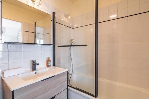 uma casa de banho com um lavatório e um chuveiro em DISNEYLAND - WIFI - PARKING - CENTRE VILLE em Bailly-Romainvilliers