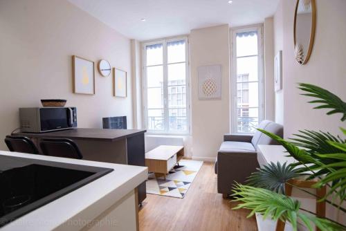 un salon avec une cuisine et un salon avec un canapé dans l'établissement Studio du Temple des Jacobins au cœur de Lyon AIL, à Lyon