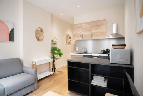 une cuisine avec un comptoir, un four micro-ondes et une chaise dans l'établissement Studio du Temple des Jacobins au cœur de Lyon AIL, à Lyon