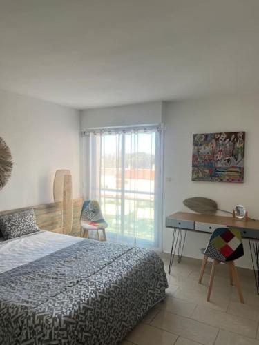 une chambre avec un lit, un bureau et une fenêtre dans l'établissement Superbe Appartement Vue Mer T3 70m2, à Mauguio