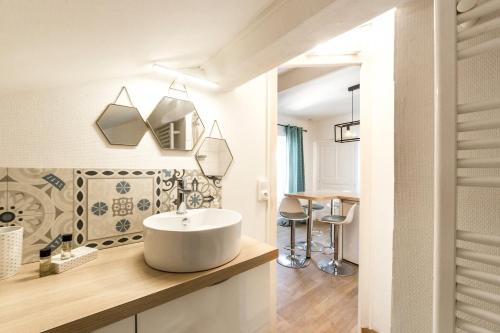 a bathroom with a white sink and a table at My little pleasure from the 8th AIL in Lyon