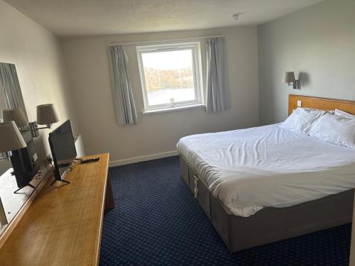 Thurrock Hotel M25 Services في آفلي: غرفه فندقيه بسرير ونافذه