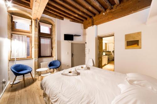 - une chambre avec un grand lit et deux chaises bleues dans l'établissement La suite Bibliothèque - Quartier historique AIL, à Lyon