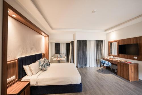 ハルガダにあるGolden Beach Resortのベッドとデスクが備わるホテルルームです。
