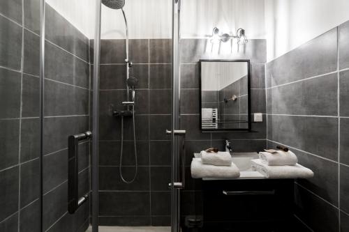 La salle de bains est pourvue d'une douche, d'un lavabo et de serviettes. dans l'établissement Spacious and cozy in Vieux Lyon AIL, à Lyon