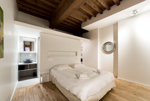 une chambre avec un grand lit blanc dans une pièce dans l'établissement Le Petit Change - Studio tout équipé en Lyon AIL, à Lyon