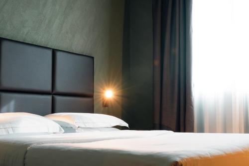a bedroom with a bed with a headboard and a window at Point Hotel in Piove di Sacco