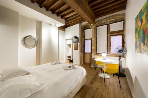 a bedroom with a white bed and a table at Le Petit Change - Fully equipped studio in Lyon in Lyon