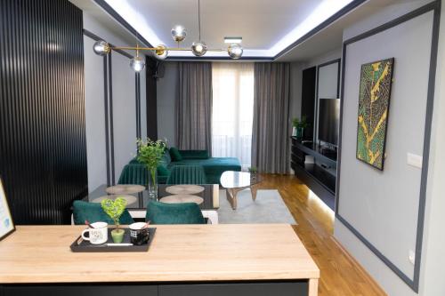 sala de estar con mesa y sillas verdes en Unity Luxury Apartment - Skopje en Skopje