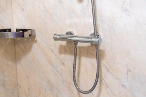 a shower head on a wall in a bathroom at Stourbridge 2 Bedroom Apartment - Netflix & WIFI - Parking - Top Rated - 1CS in Amblecote