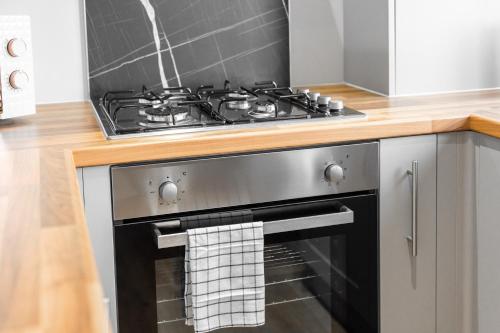 a stove top oven with a towel hanging from it at Stourbridge 2 Bedroom Apartment - Netflix & WIFI - Parking - Top Rated - 1CS in Amblecote
