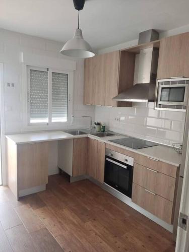 uma cozinha com armários de madeira e uma bancada em Apartamento La Mar em Carboneras