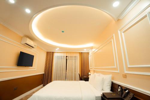 a hotel room with a bed and a tv at Dolce Mia Home Ninh Bình in Ninh Binh