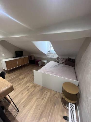 a room with a bed and a table and a chair at Appartement centre ville. in Bastia