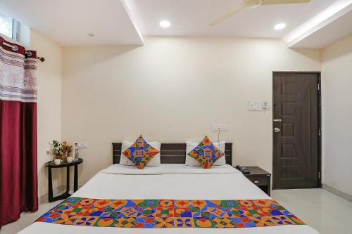 a bedroom with a bed and a brown door at FabExpress Girija Inn in Nagpur