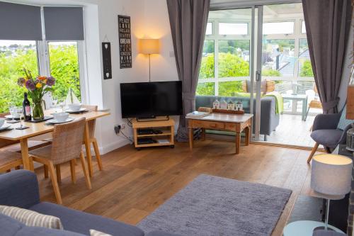a living room with a television and a table and chairs at Tryweryn Cottage Saundersfoot in Saundersfoot