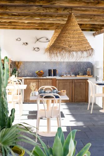 a kitchen with white chairs and a table at Casa Idalia Boutique Hotel in Comporta