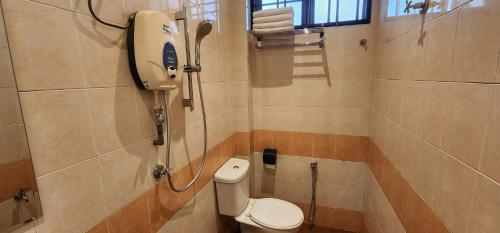 uma casa de banho com um WC e um chuveiro em Eighteen Guesthouse em Kuantan