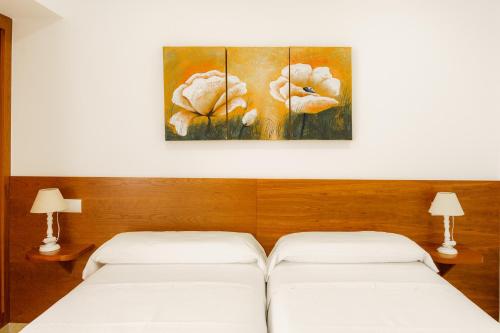 two beds in a room with a painting on the wall at Santa Margarita - Benisun in Benidorm
