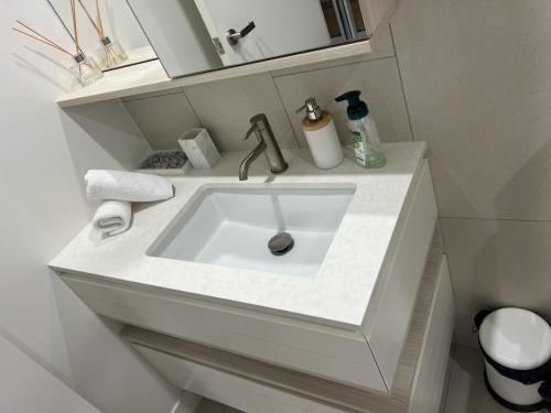 a bathroom with a white sink in a room at Beautiful Ocean View Apartment Signature Broadbeach in Gold Coast