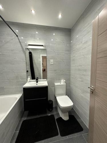 y baño con aseo, lavabo y bañera. en Impeccable 2-Bed Apartment in London, en Hendon