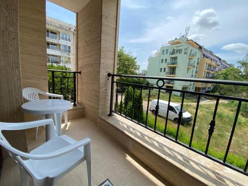 a balcony with a table and chairs and a view of a building at Apartments Amara Sunny Beach in Sunny Beach