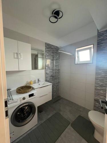 a bathroom with a washing machine and a sink at Confort Residence in Craiova
