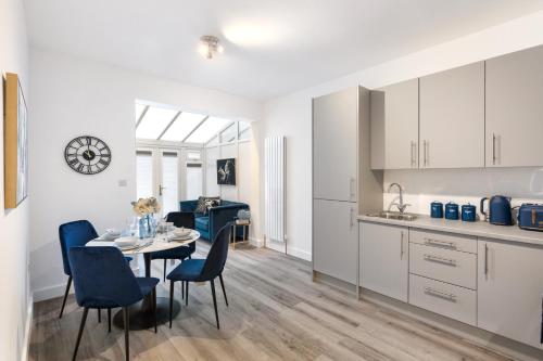 a kitchen and dining room with a table and chairs at Modern 2 Bedroom APT 3 min walk to Tube station in London