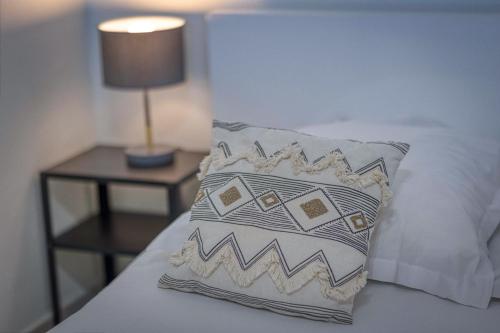 a pillow sitting on top of a bed with a lamp at L'Hôtelier - CHU / Bein Sport/Canal + in Meylan
