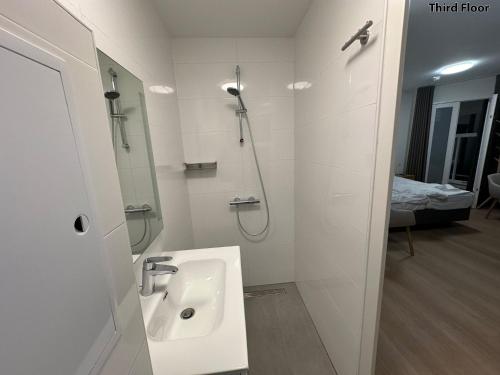 a white bathroom with a sink and a shower at Voyagers Amsterdam in Amsterdam