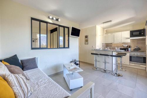 un salon avec un canapé et une cuisine dans l'établissement L'Hôtelier - CHU / Bein Sport/Canal +, à Meylan