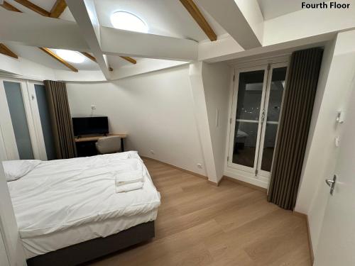 een slaapkamer met een wit bed en een raam bij Voyagers Amsterdam in Amsterdam