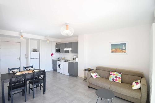 un salon avec un canapé et une table et une cuisine dans l'établissement Estacade - Capbreton en front de mer à deux pas de l'océan proche restaurants, à Capbreton