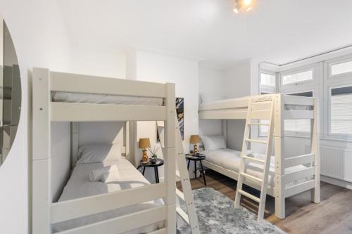 two bunk beds in a room with a ladder at Modern 2 Bedroom APT 3 min walk to Tube station in London