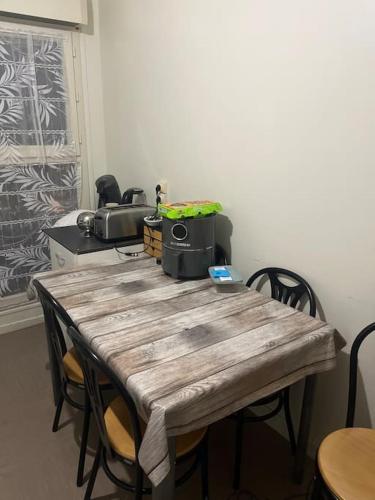 uma mesa de madeira com cadeiras num quarto em Appartement proche Disney em Noisiel