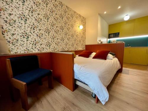une chambre avec un lit et une chaise dedans dans l'établissement CHEVREUIL studio au calme et confortable en centre ville, à Caen