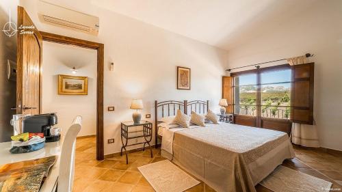 sypialnia z łóżkiem i dużym oknem w obiekcie Locanda in Vigna w mieście Arzachena