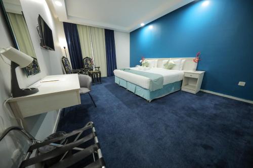 a bedroom with a bed and a blue wall at فندق برهان الهدى Burhan Al-Huda ,Hotel in Makkah