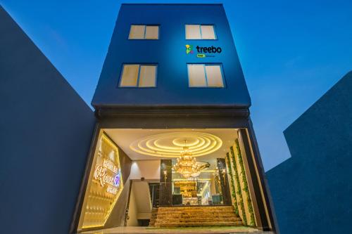 a hotel entrance with a blue building with a chandelier at Treebo Trend Taj Dream Agra in Agra