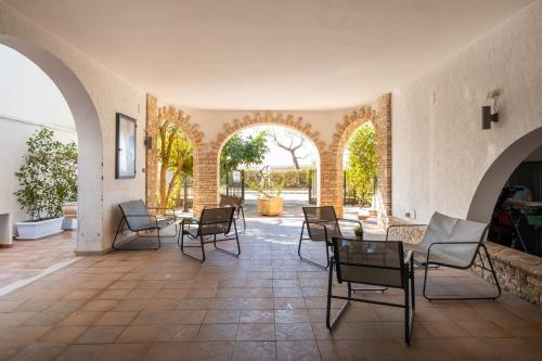 a patio with chairs and tables in a building at Villa Gaudì - Milà in Sant'Isidoro