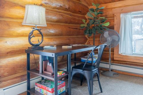 a desk with a lamp and a chair in a room at Tucked Away Timbers in Fairbanks