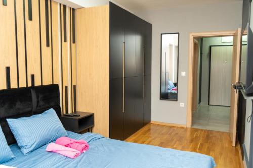 - une chambre avec un lit et des serviettes roses dans l'établissement Unity Luxury Apartment - Skopje, à Skopje