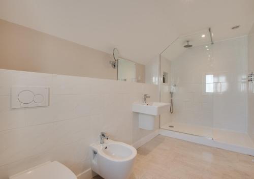 a white bathroom with a toilet and a sink at Barton Farm in West Down