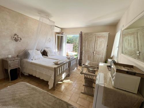 a bedroom with a white bed and a window at Bastide du Levant in Sainte-Maxime