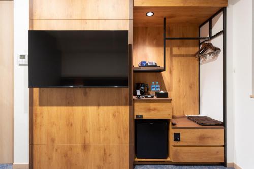 a kitchen with a large television in a room at Hotel Sundays Amami in Amami